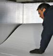 contractor installing TerraBlock™ floor insulation in a New Buffalo crawl space
