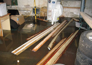 A severely flooding basement in New Buffalo, with lumber and personal items floating in a foot of water